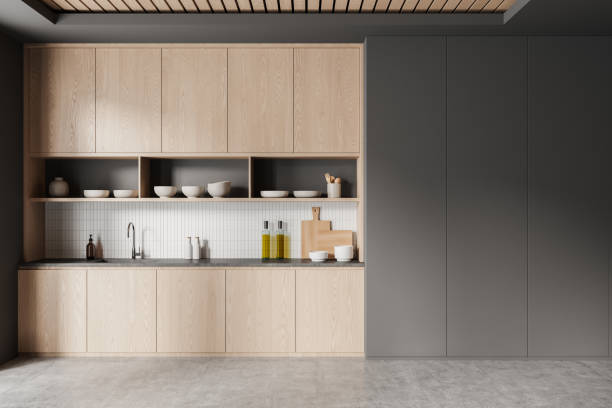 istock Modern kitchen interior featuring light wood cabinets, open shelving with kitchenware, and a white tiled backsplash, set against a dark background. 3D Rendering 2178301284