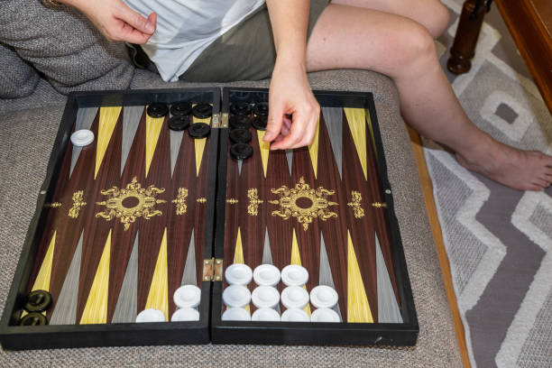 istock Woman playing backgammon on sofa, backgammon playground and dice. 2178301337