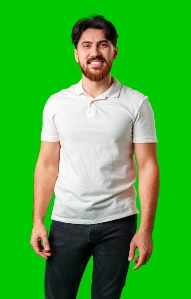 istock A smiling young man with a beard poses against a bright green background 2178301897