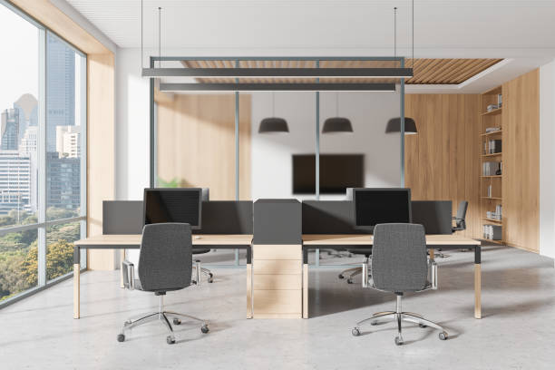istock A modern open space office with wooden interior, featuring desks, chairs, and computers. Large windows provide a city view, creating a business concept. 3D Rendering 2178301906