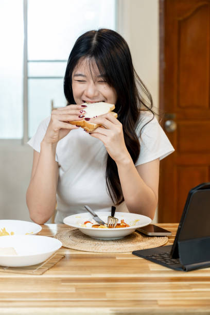 istock A happy Asian woman is having breakfast. 2178302980