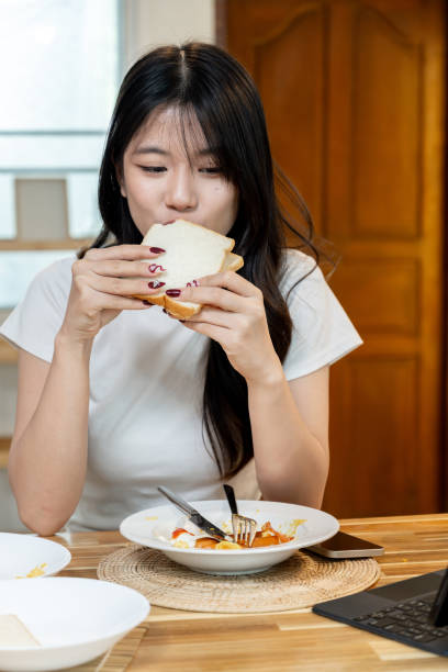 istock A happy Asian woman is having breakfast. 2178303052