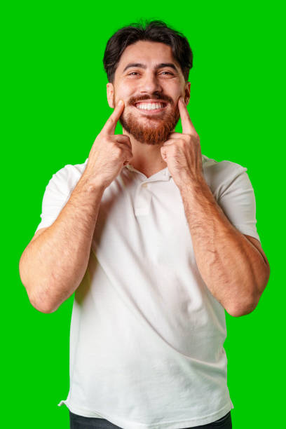 istock A man with a beard smiles confidently against a bright green background 2178303916