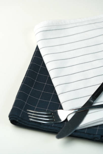 istock Cutlery placed on contrasting black and white napkins ready for dining at a table setting 2178303982