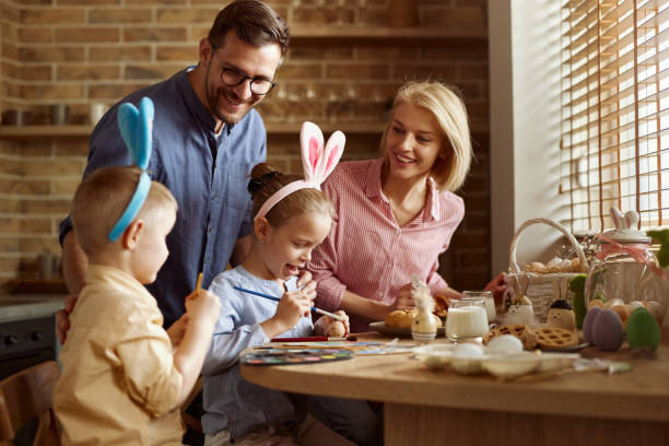 istock Happy family coloring Easter eggs in dining room. 2178304235