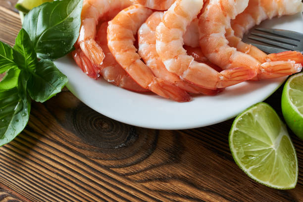 istock Boiled shrimp with lime and basil on a wooden table, closeup 2178304382