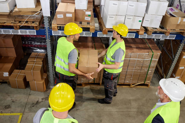 istock Above view of manual workers working with packages in storage room. 2178304903