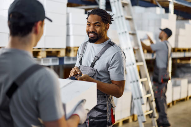 istock Happy black worker talking to his colleague in a warehouse. 2178305181