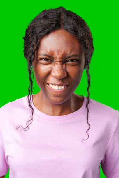 istock Happy young woman making a playful face against a bright green backdrop 2178305308
