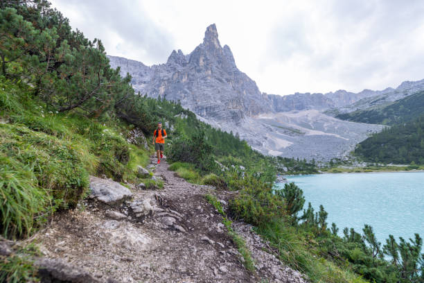istock Man Trail Running by Turquoise Mountain Lake 2178305377
