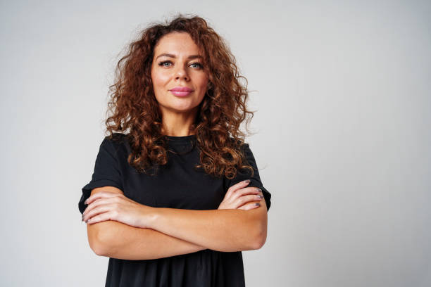 istock Confident woman with curly hair posed against a neutral background 2178307823