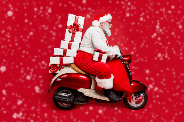 istock Profile side view of nice bearded focused funky fat Santa riding moped pile stack winter fairy purchases isolated on bright vivid shine vibrant red color background 2178310265