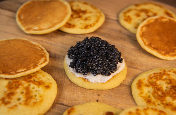 istock Blinis with black caviar and cream cheese, on a festive dish, mini pancakes, an elegant appetizer 2178311181