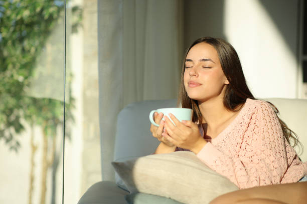 Woman relaxing at home drinking tea stock photo
