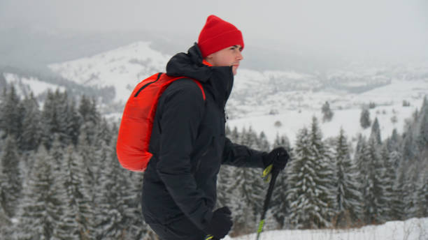 istock Male hiker ascends slope in winter 2178311922