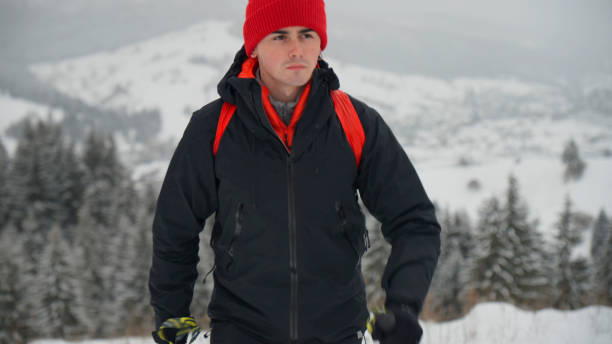 istock Male hiker ascends slope in winter 2178312041