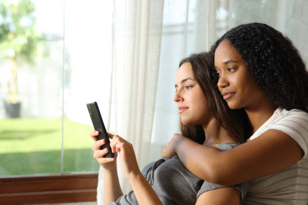 istock Serious interracial lesbian couple checking smart phone 2178312484
