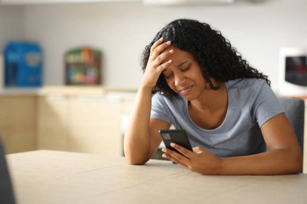 istock Sad woman checking phone in the kitchen at home 2178312517