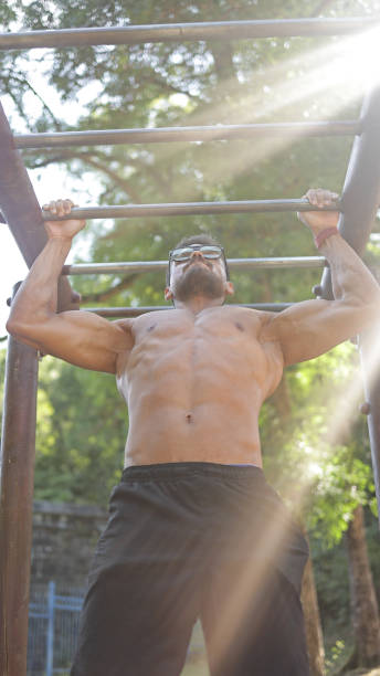 istock Muscular Young Male Athlete Doing Pull-Up on Horizontal Bar in Fitness Park, Man Doing Pull-Up on Outdoor Bar, Muscular Handsome Man Doing Exercise on Horizontal Bar, Fitness and Bodybuilding Concept Outdoor, Morning exercising outdoors 2178314143