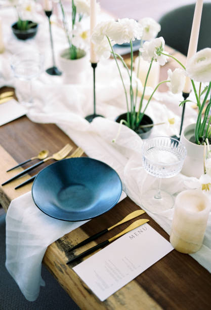 istock Black plate stands on a napkin next to the holiday menu on a set table 2178314216