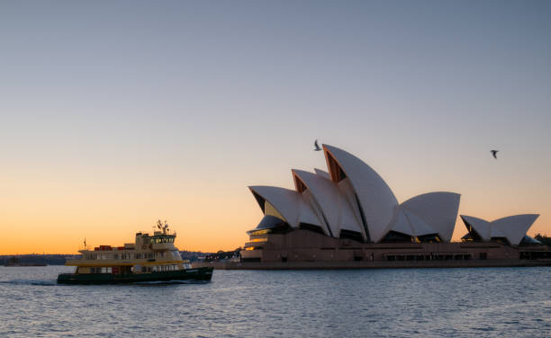 Sydney Australia - August 5, 2017: Early morning in Sydney, and a ferry steams across Circular Quay, passing the iconic form of the city's Opera House