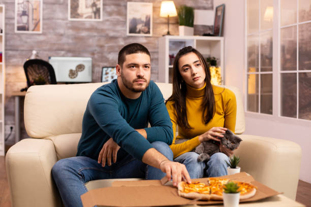 istock Gorgeous young couple eating pizza while watching TV 2178316604