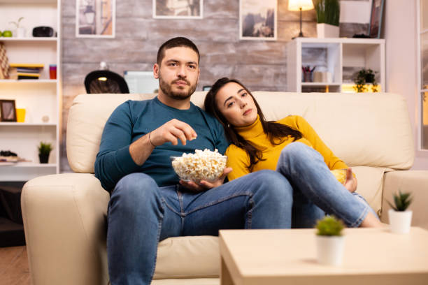 istock Handsome couple at home eating pop corn and watching TV 2178316705