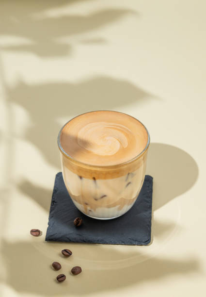 istock Dalgona coffee. Whipped instant coffee in a glass with ice on a yellow background with coffee beans 2178317733
