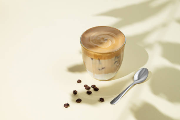 istock Iced dalgona coffee. Whipped instant coffee in a glass with ice on a yellow background with coffee beans, spoon and shadow. 2178317998