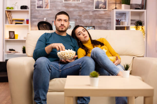 istock Handsome couple at home eating pop corn and watching TV 2178318990