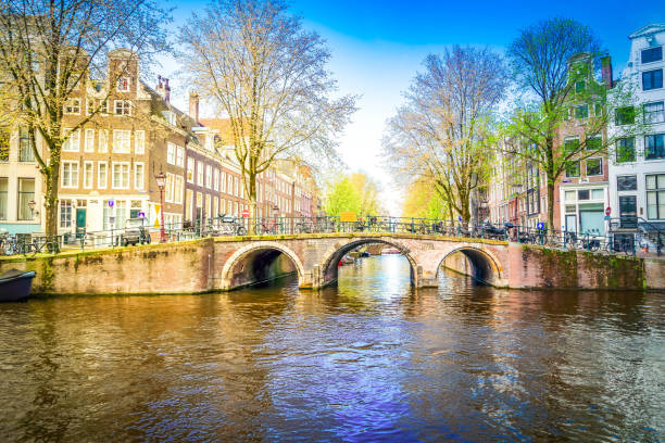 Facades of old historic Houses and traditional bridge over canal water, Amsterdam, Netherlands