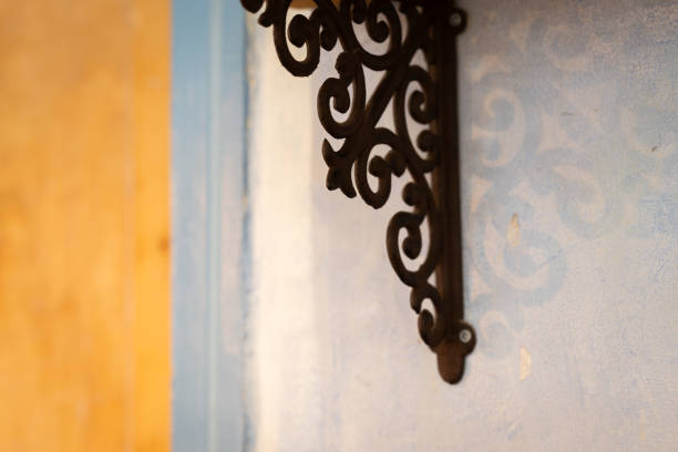 Interior in pastel colors with shelf detail, background. Vintage wrought iron shelf bracket with shadow. Interior background.
