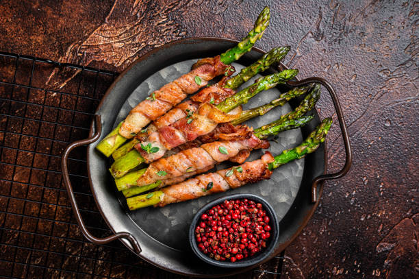 istock Baked Prosciutto wrapped green asparagus. Dark background. Top view 2178321582