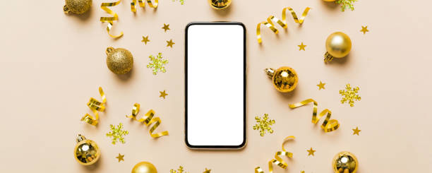 istock Christmas online shopping from home phone with blank white display top view. smart mobile with copy space on colored background with Christmas decorations balls,. Winter holidays sales background 2178327452