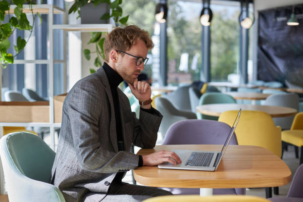istock Focused businessman working on laptop in modern office cafeteria 2178331345