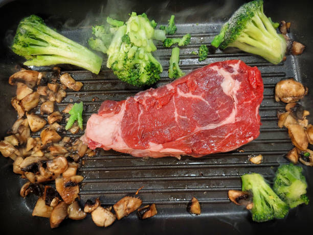 A keto-friendly meal featuring a juicy ribeye steak grilling alongside low-carb vegetables like broccoli and mushrooms. This vibrant dish is ideal for anyone following a ketogenic diet, emphasizing healthy fats and protein while keeping carbs minimal