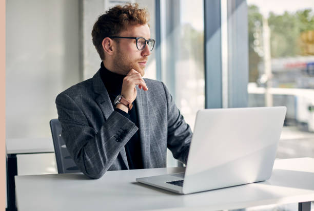 istock Pensive businessman working on laptop is thinking about solution for project in modern office 2178332483