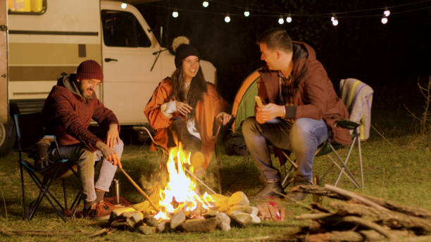 istock Bearded man telling a funny joke to his friends around camp fire 2178334544