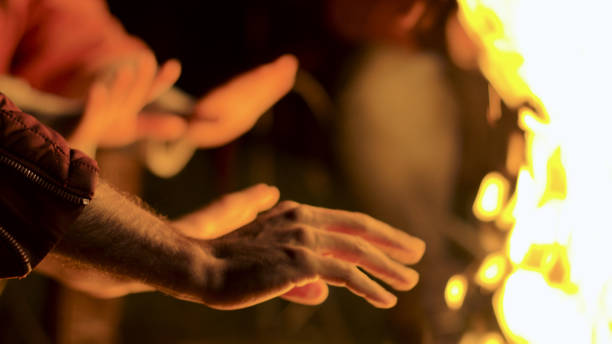 istock Close up of man warming up his hands at camp fire 2178334594