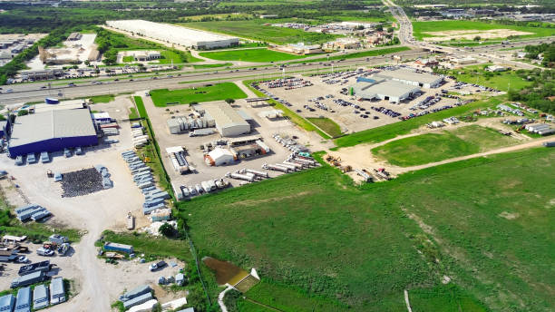 Busy interstate highway I-35 with overpass in industrial zonings manufacturer warehouse near large vacant land in New Braunfels, suburb San Antonio, Texas, fast growing urban sprawl, aerial view. USA concurrida autopista interestatal i-35 con paso elevado en el almacén del fabricante de zonificaciones industriales cerca de un gran terreno baldío en new braunfels, suburbio de san antonio, texas, expansión urbana de rápido crecimiento, vista aérea