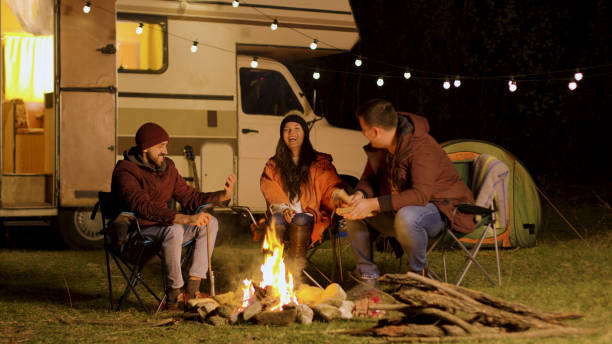 istock Group of close friends laughing together around camp fire 2178334790