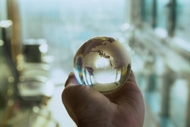 istock Hand Holding a Glass Globe in Bright Office 2178335046