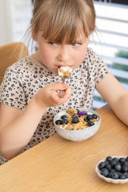istock The girl has granola with yogurt and berries for breakfast on the table. 2178335428