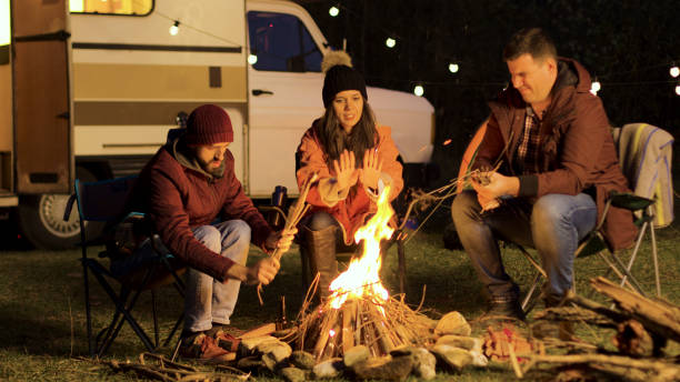 istock Girl warming up her hands while her friend making the fire stronger 2178335585