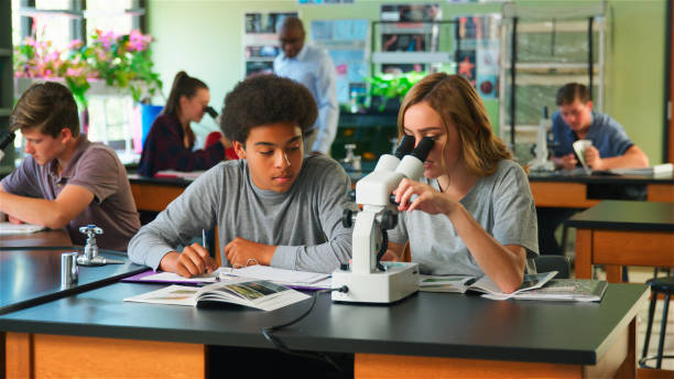 istock Male And Female High School Students Using Microscope In Biology Class 2178335982
