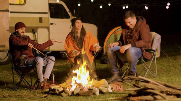 istock Bearded man telling a funny joke to his friends around camp fire 2178336300