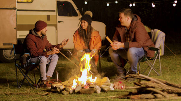 istock Bearded man telling a funny joke to his friends around camp fire 2178336420