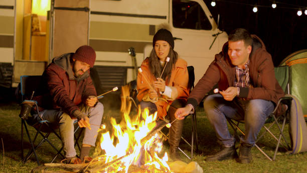 istock Friends relaxing around camp fire and roasting marshmallows on sticks 2178336483