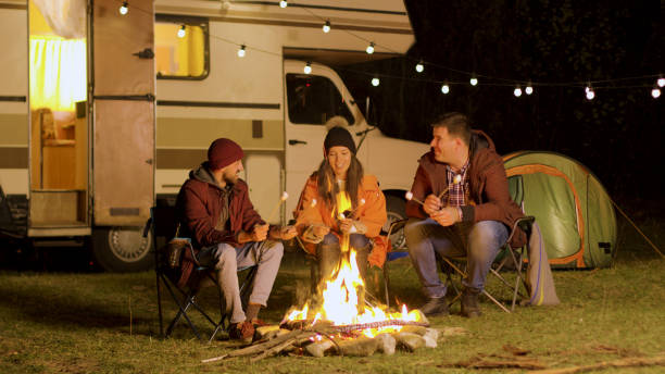 istock Group of happy friends around burning camping fire 2178336512