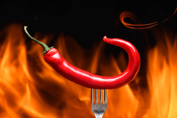 istock red chili pepper, pricked on a fork, on a background of burning fire, hot flames, on a black background 2178337227